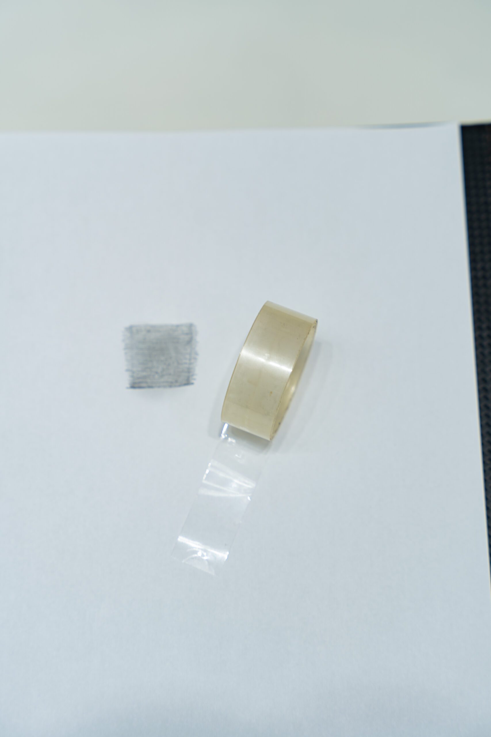 Kéo 1 đoạn băng dính trong vừa đủ để mặt có keo dính ngửa lên trên một bề mặt phẳng, sạch sẽ